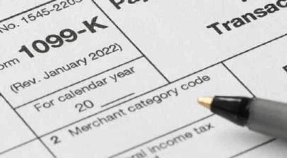 Close-up of a 1099-K tax form with a pen pointing toward the blank fields.